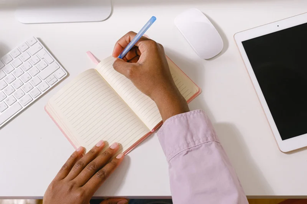 A woman taking notes on a notebook)